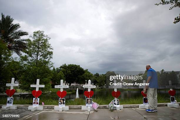 Man visits a memorial with wooden crosses for each of the 49 victims of the Pulse Nightclub next to the Orlando Regional Medical Center, June 16,...