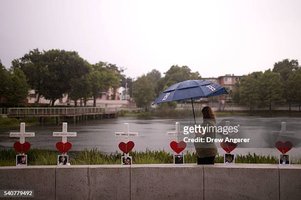 Woman visits a memorial with wooden crosses for each of the 49 victims of the Pulse Nightclub next to the Orlando Regional Medical Center, June 16,...