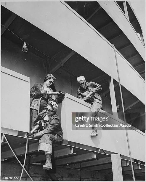 "Chippers", or women war workers of Marinship Corp, riveting on a ship during World War 2, 1942. Image courtesy National Archives. .