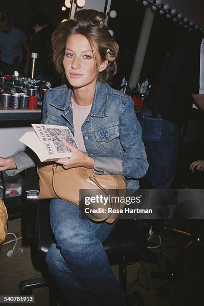 Brazilian fashion model Gisele Bundchen with a copy of the book 'The Lost Books of the Bible and the Forgotten Books of Eden', circa 2000.