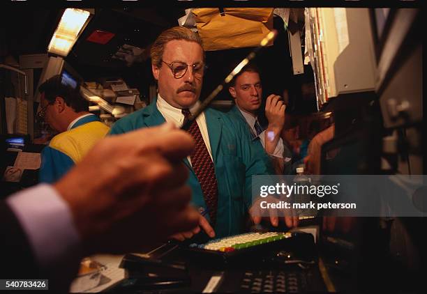 Stock exchange traders hurriedly buy and sell stocks on the New York Stock Exchange trading floor. | Location: Financial District, Lower Manhattan,...