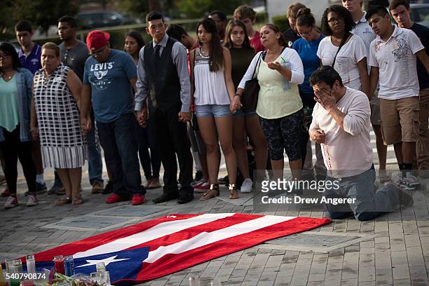 Jose Manuel Morales, friend of Edward Sotomayor who was killed in the mass shooting at Pulse Nightclub, kneels in front of a Puerto Rican flag at a...