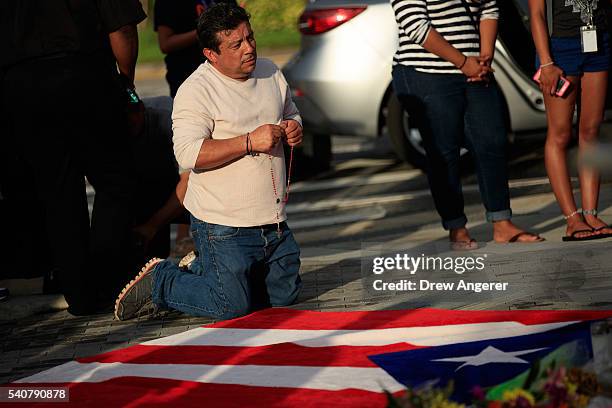 Jose Manuel Morales, friend of Edward Sotomayor who was killed in the mass shooting at Pulse Nightclub, kneels in front of a Puerto Rican flag at a...