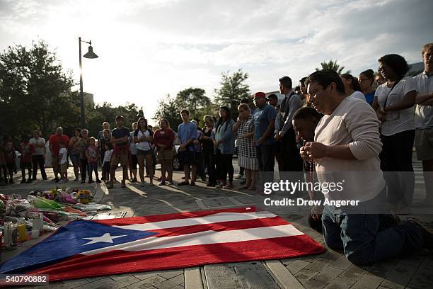 Jose Manuel Morales, friend of Edward Sotomayor who was killed in the mass shooting at Pulse Nightclub, kneels in front of a Puerto Rican flag at a...