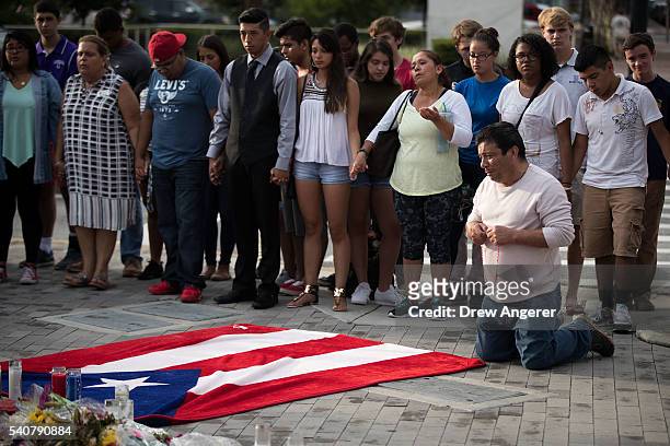 Jose Manuel Morales, friend of Edward Sotomayor who was killed in the mass shooting at Pulse Nightclub, kneels in front of a Puerto Rican flag at a...
