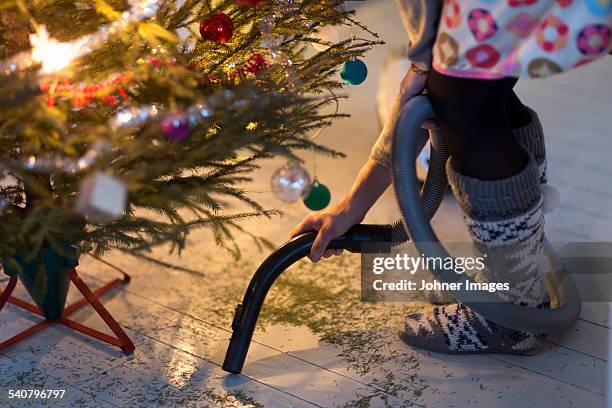 woman hovering needles under christmas tree - johner christmas foto e immagini stock