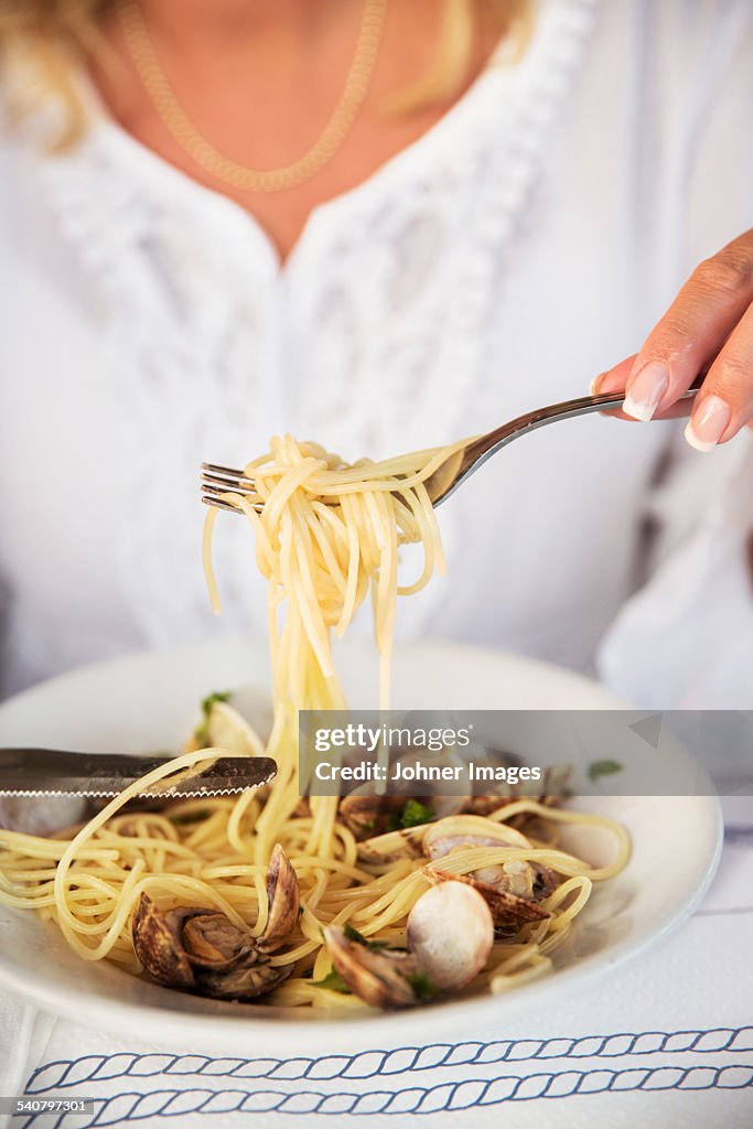 Woman eating seafood pasta