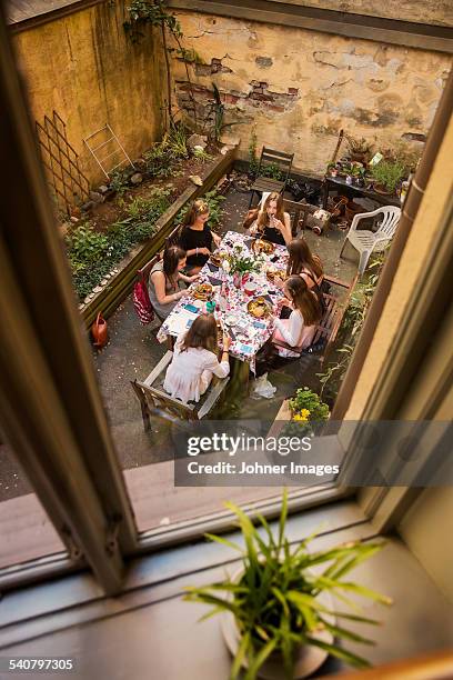 teenage girls having meal on courtyard - courtyard stockfoto's en -beelden