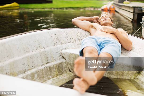 full length of mature man sleeping in boat - stockholm archipelago stock pictures, royalty-free photos & images