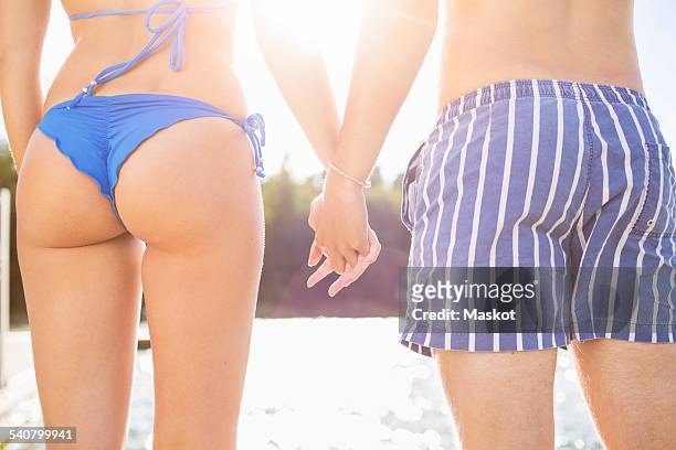midsection rear view of couple holding hands at lake - bottom up ストックフォトと画像