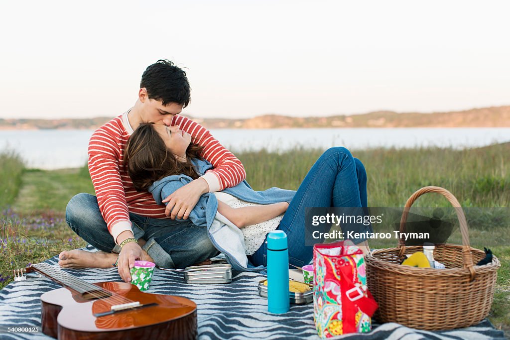 Man kissing girlfriend during picnic