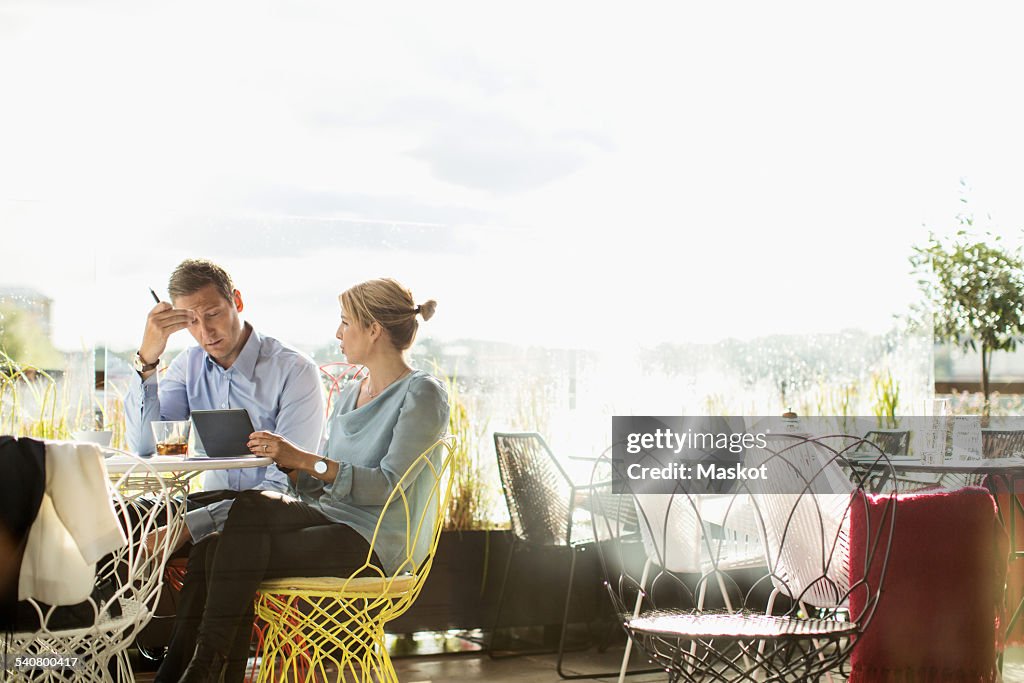 Business people working in cafe against clear sky