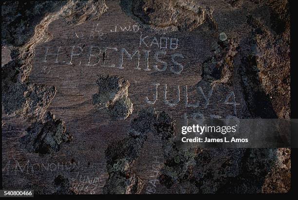 Names of pioneers who crossed the country along the Oregon Trail stand carved in Independence Rock near Casper, Wyoming. | Location: near Casper,...