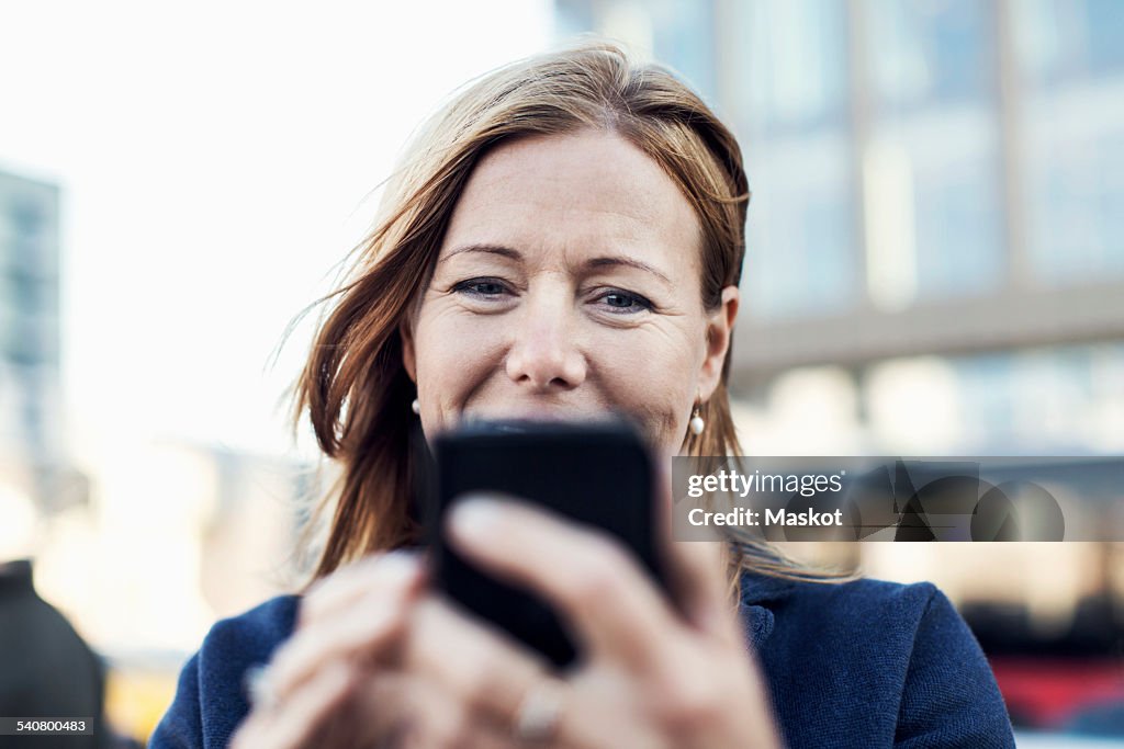 Businesswoman using mobile phone outdoors