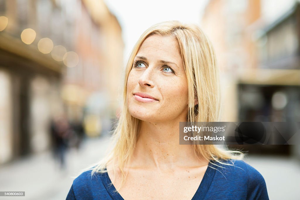 Thoughtful mid adult woman on street