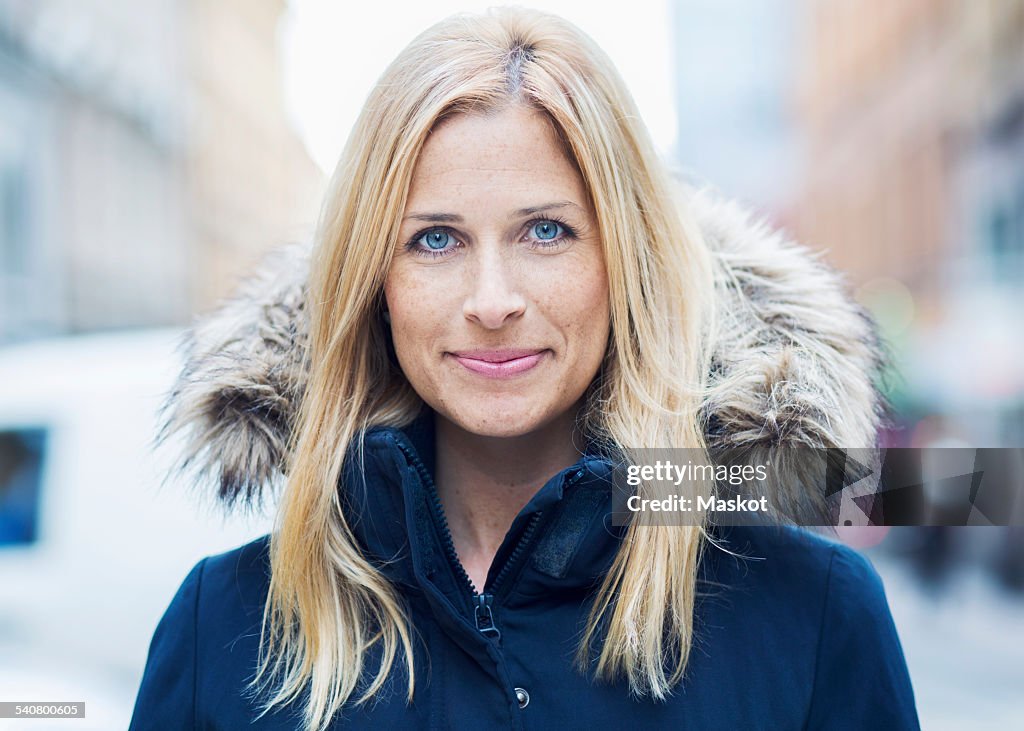 Portrait of smiling mid adult woman in city