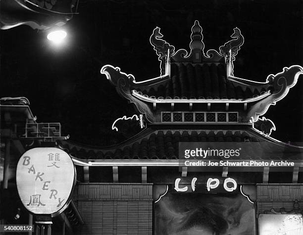 The Lipo Bakery in Los Angeles' Chinatown is illuminated at night by neon lights. 1950s. | Location: Chinatown, Los Angeles, California, USA.