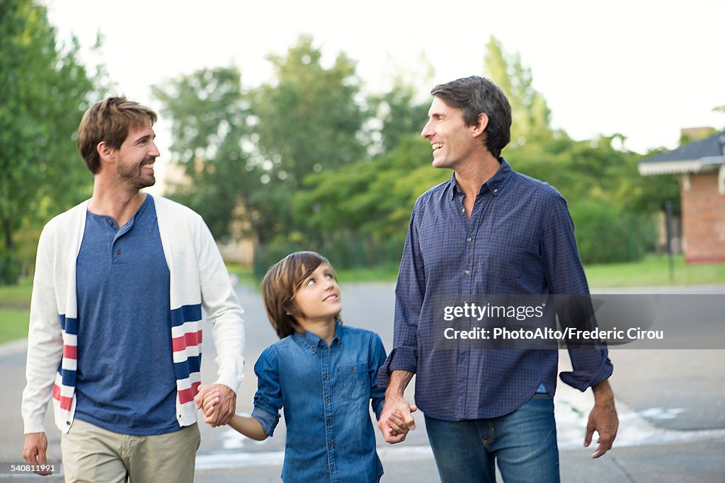 Fathers holding hands with son outdoors