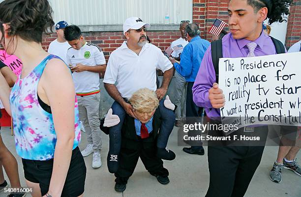 Eduardo Tamayo of Cedar Hill, Texas, wears a costume to make it appear as if he is riding on Donald Trump's back outside a rally for the presumptive...