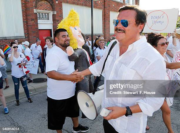 Domingo Garcia with LULAC, shakes hands with Fernando Lozano of North Richland Hills on Lamar Street near a rally for Republican presidential...