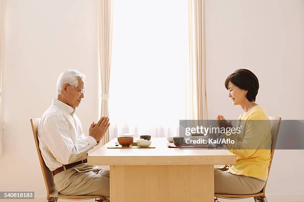 senior adult japanese couple in the kitchen - man and woman holding hands profile stock-fotos und bilder