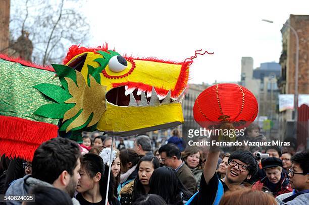 Guy with a lamp playing with the dragon during Chinese New Year Celebration, Barcelona, Spain, February 21, 2015