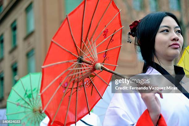 Chinese woman holds traditional red umbrella during Chinese New Year Celebration, Barcelona, Spain, February 21, 2015