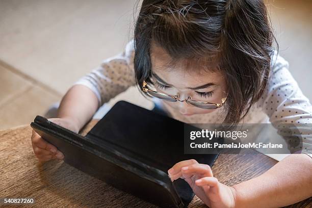 serious young japanese girl using digital tablet in living room - tablet close up real copyspace stock pictures, royalty-free photos & images