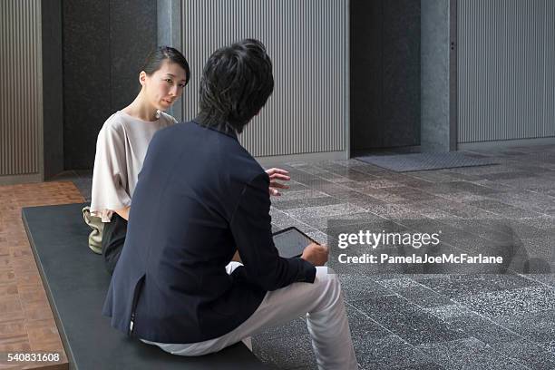 japanische geschäftsfrau, geschäftsmann mit computer-tablette, die diskussion im der lobby - meeting candid office suit stock-fotos und bilder