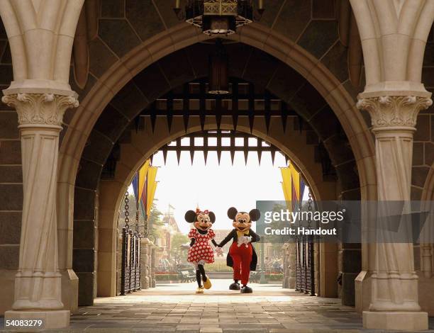 In this handout photo provided by Disney, Mickey and Minnie Mouse are seen walking through Sleeping Beauty Castle at the new Disneyland Park on...
