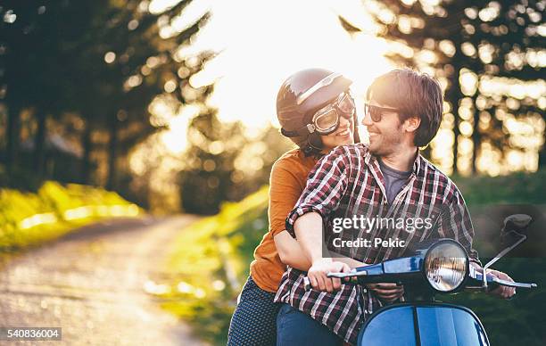 happy young couple riding vintage motorcycle - vintage motorcycle helmet stock pictures, royalty-free photos & images