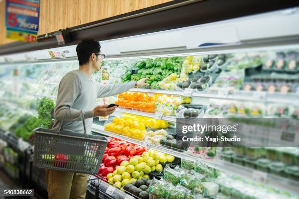 mid adult male buying grocery in supermarket - man buying groceries stock pictures, royalty-free photos & images