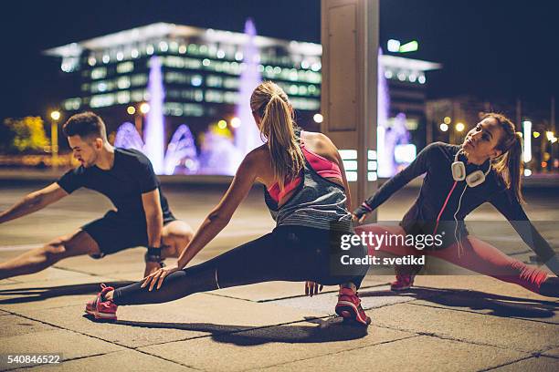 stretch your muscles - woman capturing city night stockfoto's en -beelden