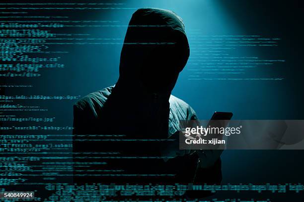 hacker usando teléfono - surveillance fotografías e imágenes de stock