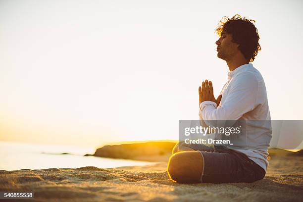 üben yoga und meditation im sommer am strand bei sonnenuntergang - beach yoga stock-fotos und bilder