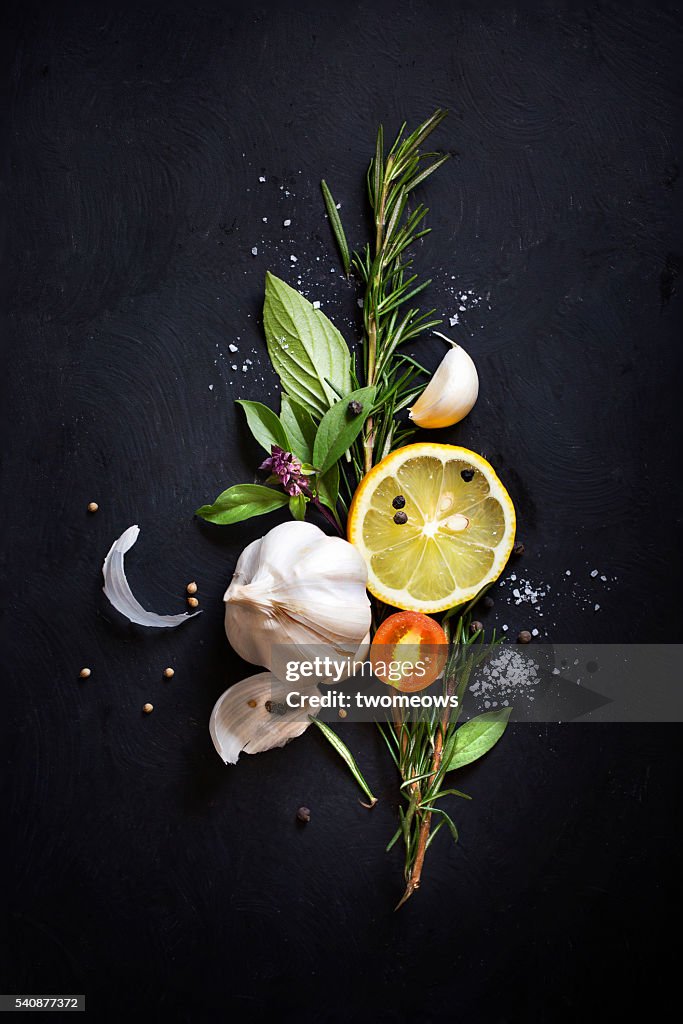 Close up image of herbs and spices on black background.