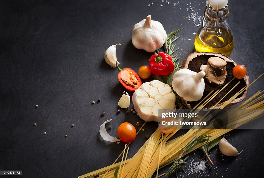 Italian food, spaghetti recipe ingredient on black texture background.