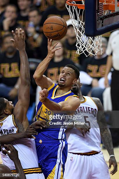 Stephen Curry of the Golden State Warriors drives to the basket against Iman Shumpert and J.R. Smith of the Cleveland Cavaliers in the second half in...