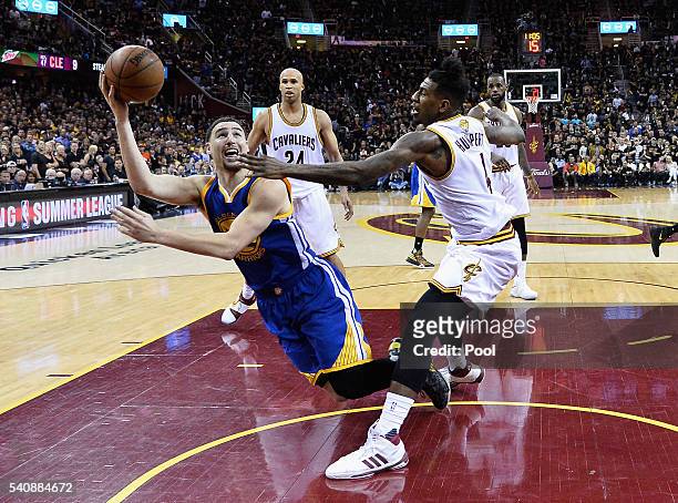 Klay Thompson of the Golden State Warriors shoots the ball as he falls during the second half against the Cleveland Cavaliers in Game 6 of the 2016...