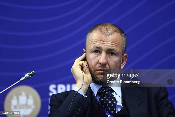 Andrey Melnichenko, billionaire and chairman of EuroChem AG, listens through an earpiece during a panel session on day two of the St. Petersburg...