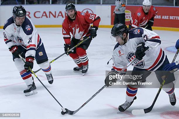 John Scott and Joe Harcharik of USA protect the puck during the match between Team USA and Team Canada at Rod Laver Arena on June 17, 2016 in...