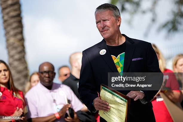 Surrounded by members of federal, state and local agencies, Orlando Mayor Buddy Dyer listens to a question at a press conference to provide an update...