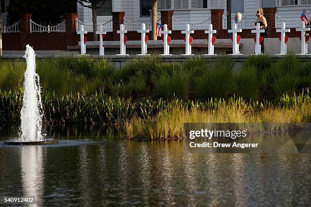 Woman pauses at a memorial with wooden crosses for each of the 49 victims of the Pulse Nightclub, next to the Orlando Regional Medical Center, June...