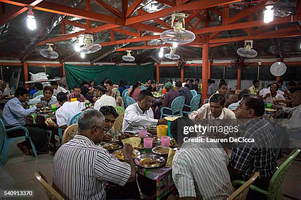 Myanmar Muslims partake in Iftari, or breaking fast, after the final evening prayer during Ramadan at the 59th Street Mosque in downtown on June 17,...
