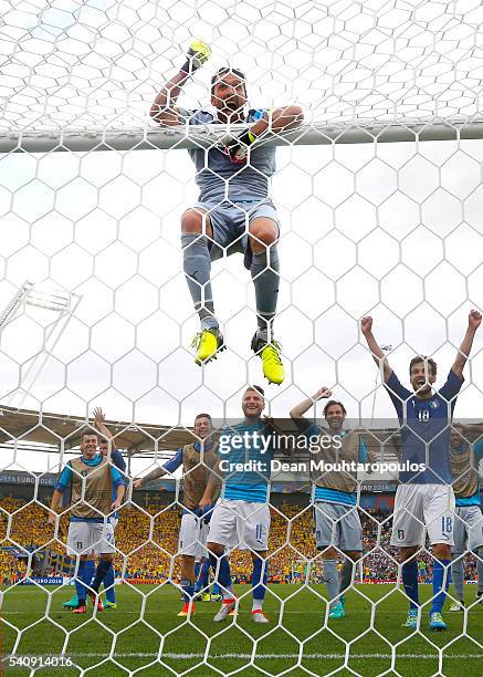 Gianluigi Buffon of Italy hangs from the crossbar as the Italian team celebrate victory in the UEFA EURO 2016 Group E match between Italy and Sweden...