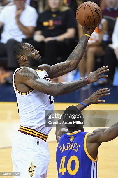 LeBron James of the Cleveland Cavaliers shoots the ball against Harrison Barnes of the Golden State Warriors in Game 4 of the 2016 NBA Finals at...