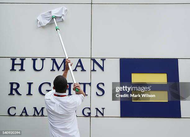 Worker cleans the wall of the Human Rights Campaign building, June 17, 2016 in Washington, DC. Images of the 49 people killed in the Orlando terror...