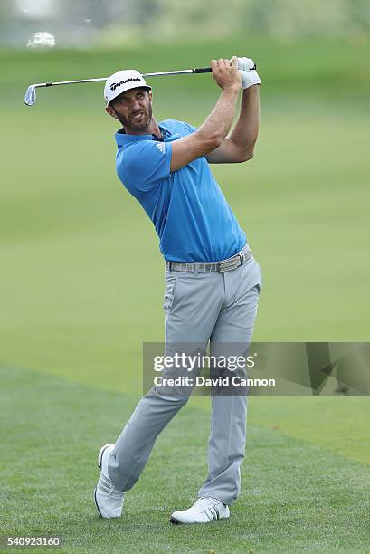 Dustin Johnson of the United States hits a shot on the ninth hole during the continuation of the weather delayed first round of the U.S. Open at...