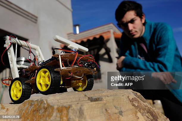 Argentinian industrial engeneering student of the National University of Cuyo, Marcos Bruno, looks at a robot made by him, in Mendoza, Argentina on...