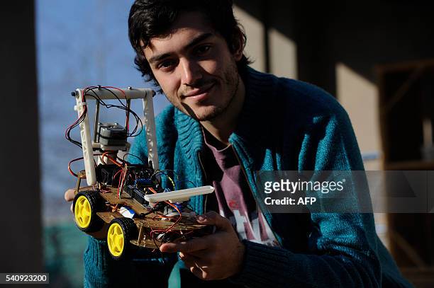 Argentinian industrial engeneering student of the National University of Cuyo, Marcos Bruno, poses with a robot made by him, in Mendoza, Argentina on...